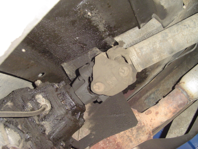Underside of a vehicle showing the transmission, driveshaft, and exhaust pipe