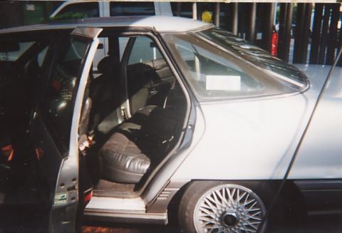 1991 Ford Taurus - The interior of a car is visible with the doors open, showing the seats and the exterior side panel.