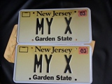 2003 Ford Excursion - Two New Jersey license plates, both displaying 'MY X' and the year '03', are shown against a dark background.