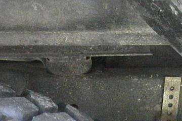 1989 Ford Bronco - Detail of vehicle undercarriage, showing frame and tire. SuperMotors.com logo is present.
