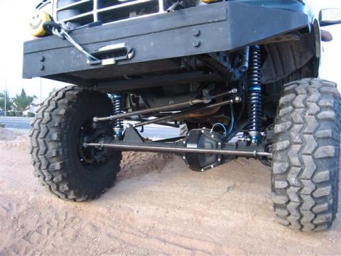 1994 Ford Bronco - Modified front axle and suspension system on an off-road vehicle with large tires.