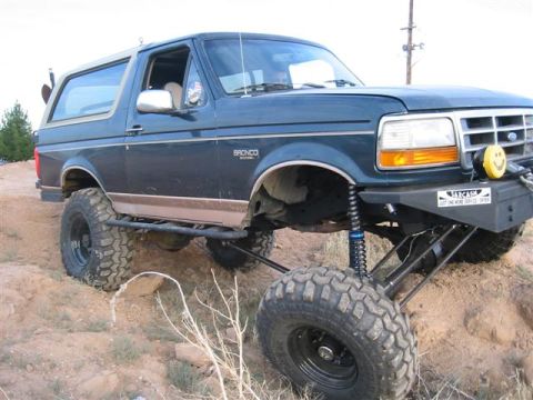 1994 Ford Bronco - This modified Ford Bronco is shown off-road, with its suspension and tires clearly visible.