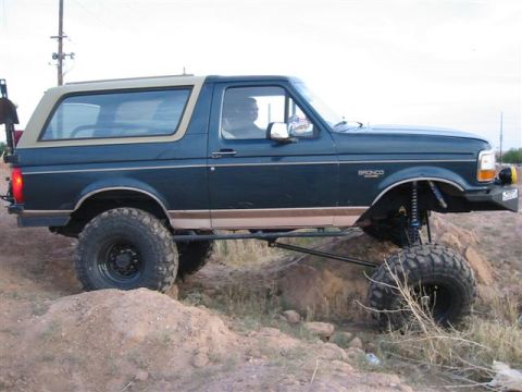 1994 Ford Bronco - This modified Ford Bronco is shown on a dirt mound, demonstrating its off-road capabilities.