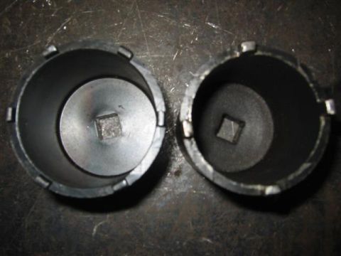 1994 Ford Bronco - Two black hubcap removal tools are shown, each with a square drive opening for a ratchet or breaker bar.