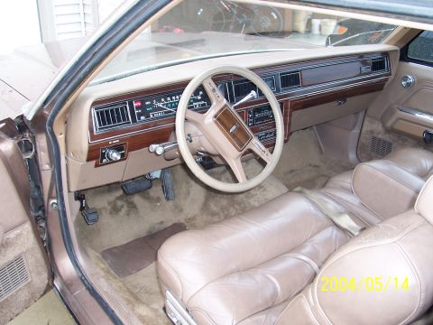 1982 Ford Crown Victoria LTD - The interior of a vintage sedan features a wood-grain dashboard and tan leather seating.