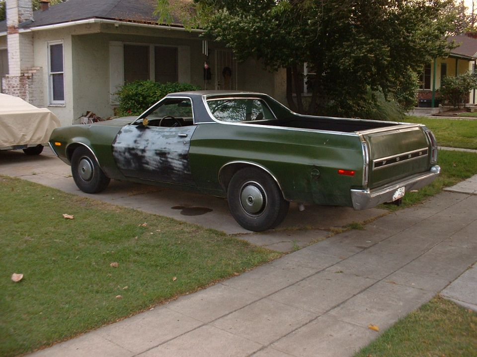 Green Ford Ranchero pickup rear 3/4 view parked in driveway
