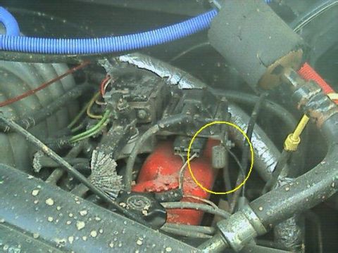1989 Ford Bronco - Close-up view of engine components, including wiring and a red-colored part.