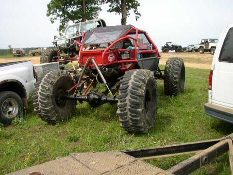 1995 Ford Bronco - Multiple custom off-road vehicles are gathered in a field, with a red buggy in the foreground.