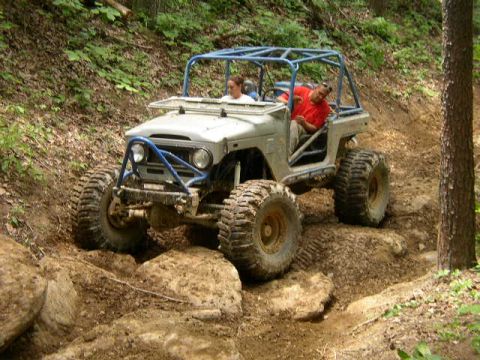 1995 Ford Bronco - Two people navigate a challenging off-road course in a modified vehicle.