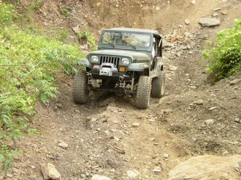 1995 Ford Bronco - Jeep Wrangler navigating an off-road trail.