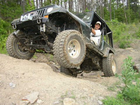 1995 Ford Bronco - A driver navigates a off-road trail in a modified Jeep Wrangler.