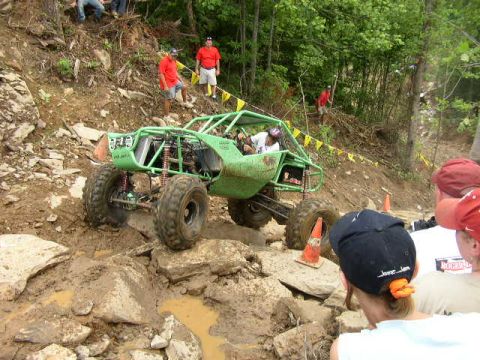 1995 Ford Bronco - A custom-built buggy navigates a challenging off-road course with spectators watching.