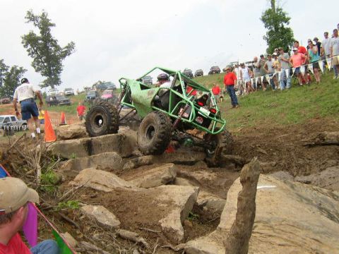 1995 Ford Bronco - A custom-built buggy navigates a challenging rock obstacle course with a crowd observing.