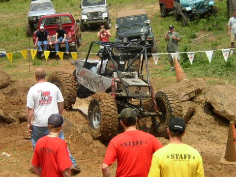 1995 Ford Bronco - A custom off-road buggy tackles a challenging mud course with spectators observing the action.