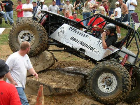 1995 Ford Bronco - A custom-built off-road buggy navigates a challenging obstacle course with spectators in the background.