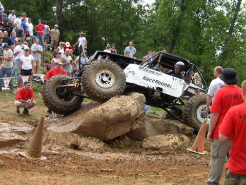 1995 Ford Bronco - Custom off-road buggy navigates a challenging rock obstacle course with spectators watching.