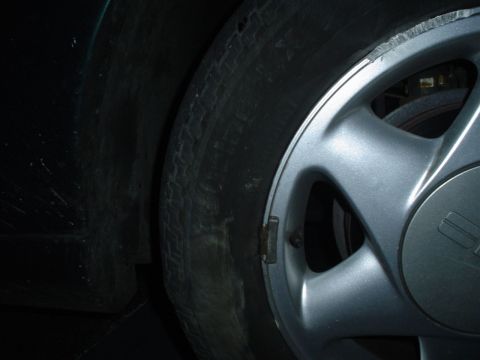 1993 Ford Taurus - Detail of a worn tire and damaged alloy wheel on a vehicle.