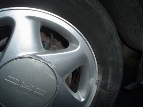 1993 Ford Taurus - A close-up view of a vehicle's wheel and tire, showing the 'DHS' logo on the hubcap.