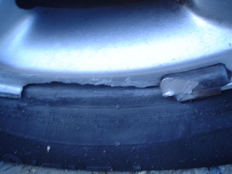 1993 Ford Taurus - A wheel weight is attached to the rim of a tire, showing a close-up view of this automotive part.