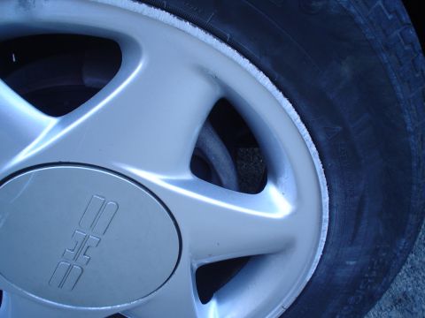 1993 Ford Taurus - A close-up view of a vehicle's wheel and tire, showing the alloy rim and tread detail.