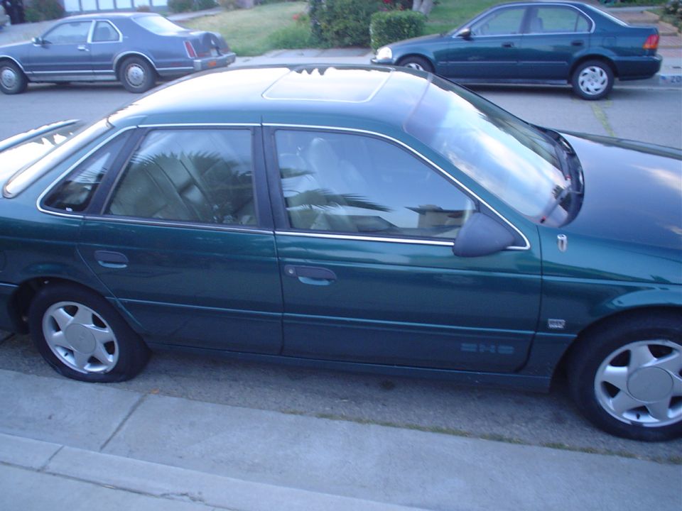 Green 1993 Ford Taurus side view with sunroof