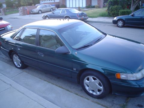 1993 Ford Taurus - This 1993 Ford Taurus is parked on a residential street next to other vehicles.