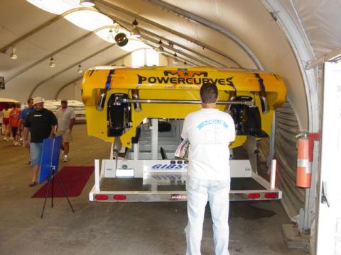 1992 Ford Bronco - A yellow boat with "POWERCURVES" branding is displayed indoors, with people observing.