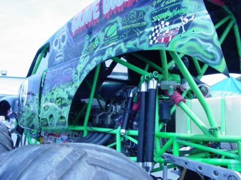 1992 Ford Bronco - Monster truck with custom flame graphics and exposed engine and suspension parts.