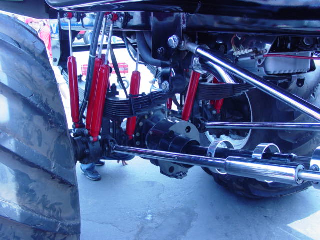 Monster truck suspension with red shocks and large tire