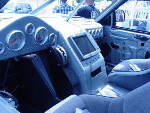 1992 Ford Bronco - The interior of a modified vehicle features custom gauges and a central console with a screen.