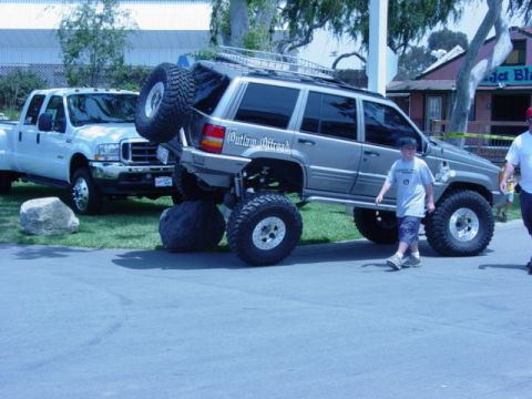 1992 Ford Bronco - A heavily modified Jeep Grand Cherokee is displayed next to a white Ford pickup truck.