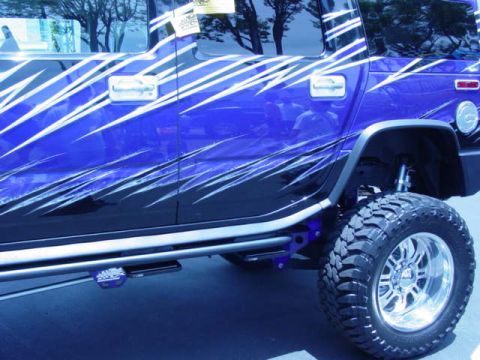 1992 Ford Bronco - A modified blue SUV with custom graphics and off-road tires is shown from the side.