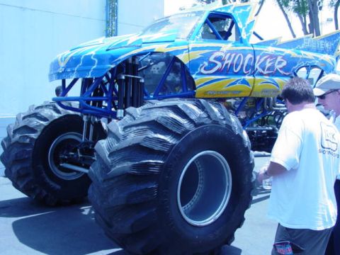 1992 Ford Bronco - The 'Shocker' monster truck, adorned with blue and yellow lightning graphics, is displayed with its massive tires.