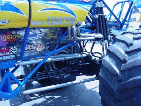 1992 Ford Bronco - Close-up of monster truck suspension and exhaust system, with "4SHOCKER" branding visible.