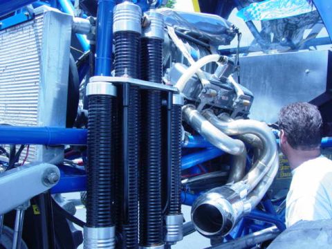 1992 Ford Bronco - A person looks at the complex engine and suspension of a custom off-road vehicle.
