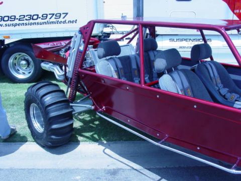 1992 Ford Bronco - A custom dune buggy with a roll cage and racing seats is displayed next to a large truck.