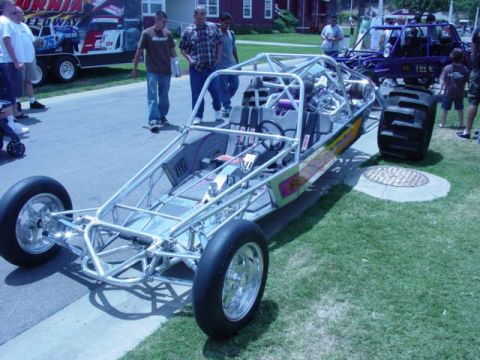 1992 Ford Bronco - A custom dune buggy with a roll cage and exposed frame is displayed outdoors, with another vehicle in the background.