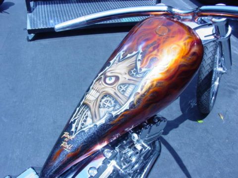 1992 Ford Bronco - A motorcycle fuel tank displays a detailed airbrushed skull and flame design with "Rock n Roll" text.