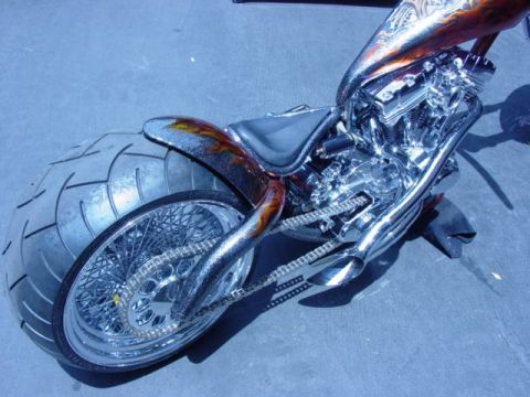 1992 Ford Bronco - A custom motorcycle with a flame motif on the fender and a highly polished chrome engine is displayed outdoors.