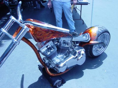 1992 Ford Bronco - Custom motorcycle with flame paint and chrome details on display.