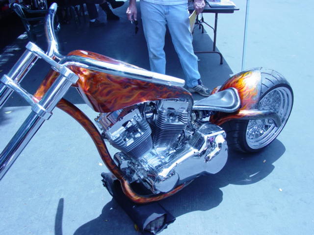 Custom motorcycle with flame paint on the fuel tank and rear fender, chrome engine and exhaust