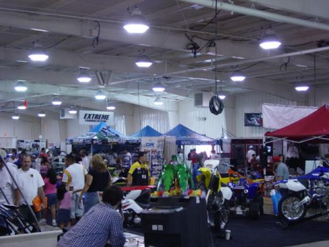 1992 Ford Bronco - An indoor exhibition hall filled with various motorcycles and ATVs on display, with people browsing the stalls.