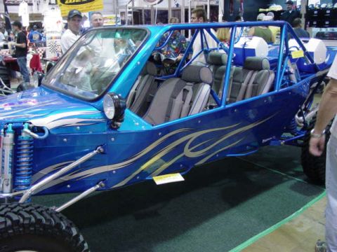 1992 Ford Bronco - A custom blue dune buggy with flame decals and a prominent roll cage is displayed indoors.