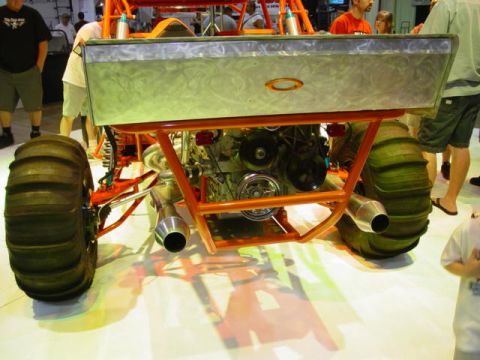 1992 Ford Bronco - This custom off-road vehicle features oversized paddle tires and a prominent engine, viewed from the rear.