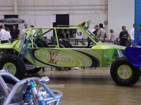 1992 Ford Bronco - A custom-built buggy with a distinctive Louis Vuitton livery is displayed indoors, with another vehicle partially visible.
