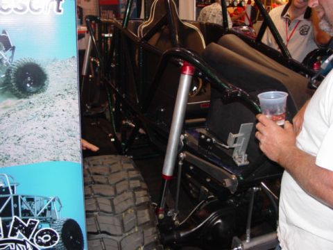 1992 Ford Bronco - An off-road buggy with a roll cage and large tires is displayed indoors.
