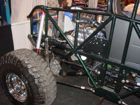 1992 Ford Bronco - A custom-built buggy with a prominent green roll cage and exposed engine is displayed indoors.
