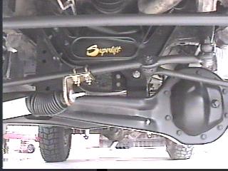 1993 Ford Bronco - The underside of a vehicle, suspension components and a Superlift logo. A tire and part of another vehicle are visible in the background.