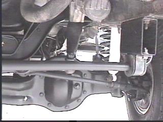 1993 Ford Bronco - Close-up of the undercarriage, showing the front axle and suspension components of a vehicle.