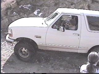 1993 Ford Bronco - White 1993 Ford Bronco navigates an off-road trail.